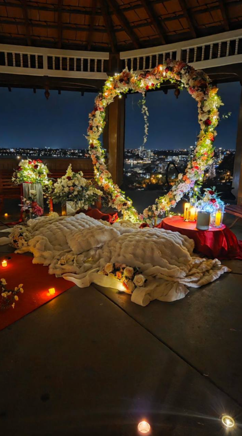 Heart-shaped floral arch with candlelight inside the gazebo